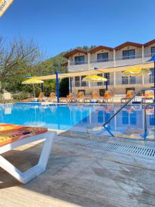 a large swimming pool with chairs and umbrellas at Emir Palas Hotel in Ekincik