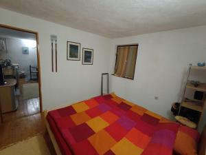 a bedroom with a colorful blanket on a bed at Vlasic Relax in Vlasic