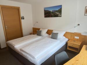 a bedroom with two beds and a chair in it at Grünwaldhof in Tux