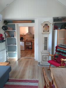 a living room with a clock and a table at Rosa's stuga in Tasebo