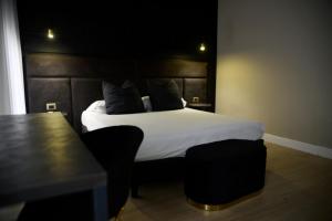 a bedroom with a bed with white sheets and a table at HT Room Spa & Suite in Brindisi +47 photos