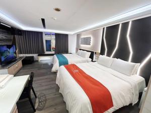 a hotel room with two beds and a television at King Motel王者 in Taoyuan