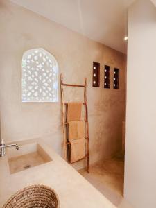 a bathroom with a sink and a towel rack at Little Maua - Stylish Private Hideaway on Galu Beach in Galu