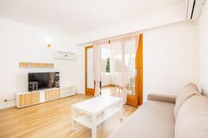 a white living room with a couch and a table at Apartamento Felipe 2-4 in Cala d´Or