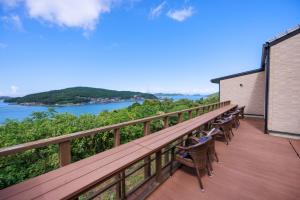 a balcony with chairs and a view of a river at Kisara Bettei TOKI in Toba
