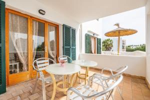 a patio with two tables and chairs on a balcony at Apartamento Felipe 2-4 in Cala d´Or