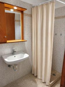 a bathroom with a sink and a shower curtain at Τηλεμαχος Apartments in Loutra Edipsou +29 photos