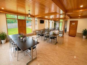 a group of tables and chairs in a room at Mountain Route Cottage in Manāli +18 photos
