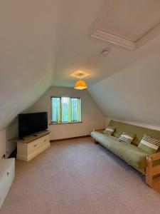 a living room with a couch and a television at Ivy House Country Hotel in Lowestoft