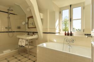 a white bathroom with a tub and a sink at Les Sources de Vougeot in Vougeot +23 photos