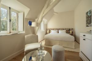 a bedroom with a bed and a desk and chair at Les Sources de Vougeot in Vougeot