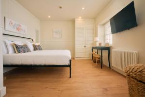 a bedroom with a bed and a desk and a television at The Godolphin Hotel in Marazion