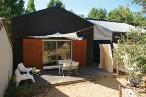 a patio with a table and chairs and an umbrella at Chalet spacieux proche mer in Longeville-sur-Mer