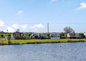 a large body of water with houses in the background at Croft Farm Water Park in Tewkesbury