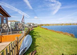 a boat sitting on the grass next to the water at Croft Farm Water Park in Tewkesbury