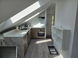 a kitchen with a staircase leading up to a loft at Apartment Ledince in Most na Soči