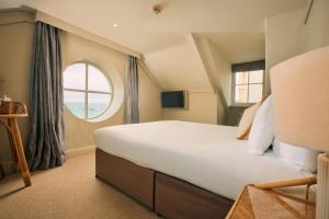 a bedroom with a large bed and a window at The Godolphin Hotel in Marazion