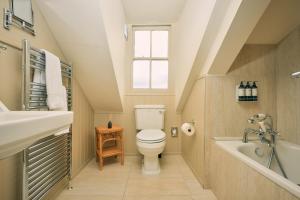a bathroom with a toilet and a sink and a bath tub at The Godolphin Hotel in Marazion +33 photos