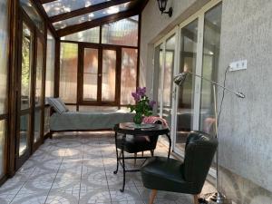 a screened in porch with a table and a chair at Tūlevél/Pine-needles in Tata