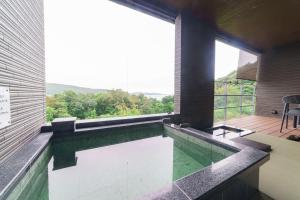 a swimming pool in a house with a large window at Kisara Bettei TOKI in Toba