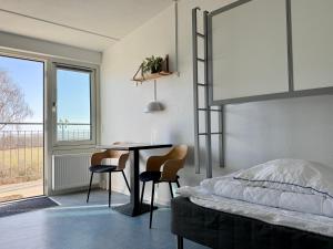 a bedroom with a bed and a table and chairs at Danhostel Rønde in Rønde