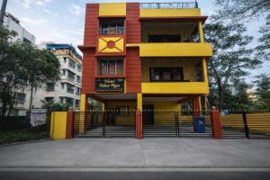 a yellow and red building with a sign on it at Collection O Yellow Rose in kolkata