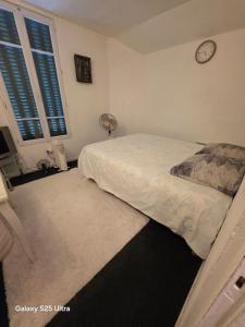 a bedroom with a bed and a clock on the wall at PR2 - 2 Bedrooms and a Fully Equipped Kitchen in Le Blanc-Mesnil +8 photos