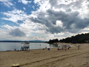 a group of people on a beach near the water at Apartament Skorochów Jezioro in Skorochow