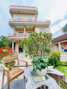 a building with a bench and flowers in front of it at Katie's homestay in Ðông Mỹ (2)
