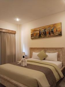 a bedroom with a bed with a stuffed animal on it at Dolot Guest House Amed Beach in Amed