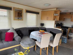 a living room with a couch and a table at my happy place caravan in Trusthorpe +13 photos
