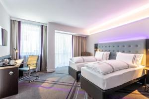 a hotel room with two beds and a desk at Premier Inn Passau Weisser Hase in Passau +16 photos