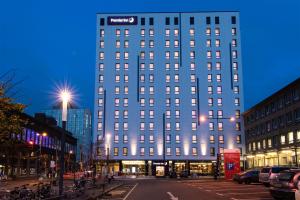 a tall building in a city at night at Premier Inn Essen City Centre in Essen