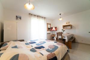 a bedroom with a bed and a table in it at Le Bellevue, 50m lac, piscine, parking, wifi, baignade surveillée in Aureilhan +24 photos
