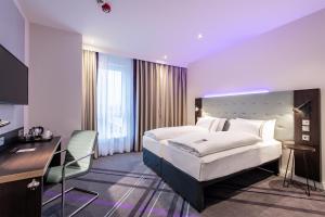 a hotel room with a bed and a desk at Premier Inn Essen City Centre in Essen +16 photos