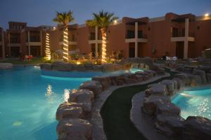 a swimming pool in a resort at night at Aquamarine Kuwait Resort(Families Only) in Al Nuwaiseeb