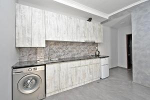 a kitchen with a sink and a washing machine at Sirik hotel in Zvartnots International Airport