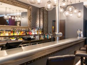 a bar with a long counter and a mirror at Premier Inn München City Zentrum in Munich