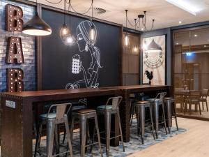 a bar in a restaurant with bar stools at Premier Inn München City Zentrum in Munich