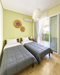 a bedroom with two beds and a window at Vassia's B rooms in Poros