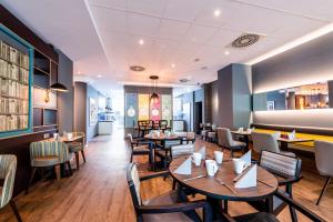a restaurant with tables and chairs and a bar at Premier Inn Essen City Limbecker Platz in Essen