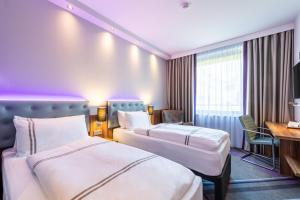 a hotel room with two beds and a desk at Premier Inn Essen City Limbecker Platz in Essen +17 photos