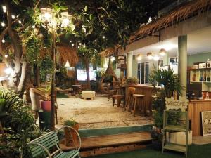 a restaurant with tables and chairs and plants at The Oasis on 8 Cozy Homestay & Café in Bangkok
