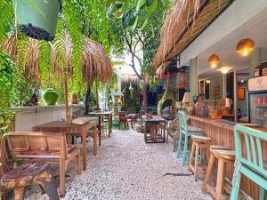 a restaurant with tables and chairs and a bar at The Oasis on 8 Cozy Homestay & Café in Bangkok