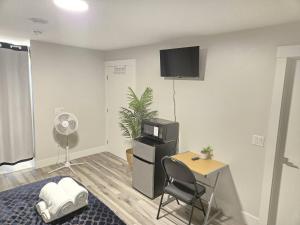 a living room with a desk and a tv on the wall at Cozy Newly Built Room in Halifax