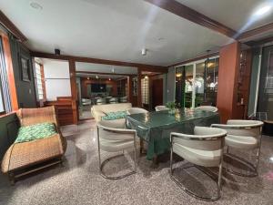 a dining room with a green table and chairs at The Oasis on 8 Cozy Homestay & Café in Bangkok
