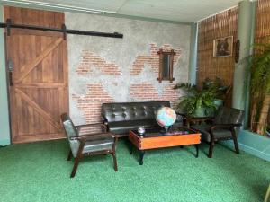 a living room with a couch and two chairs and a table at The Oasis on 8 Cozy Homestay & Café in Bangkok
