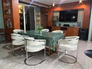 a dining room with a green table and white chairs at The Oasis on 8 Cozy Homestay & Café in Bangkok +36 photos