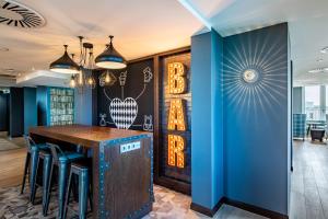 a bar in a restaurant with blue walls at Premier Inn München City Schwabing in Munich
