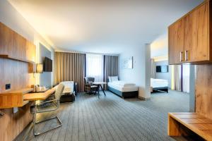 a hotel room with two beds and a desk at Premier Inn Lindau in Lindau